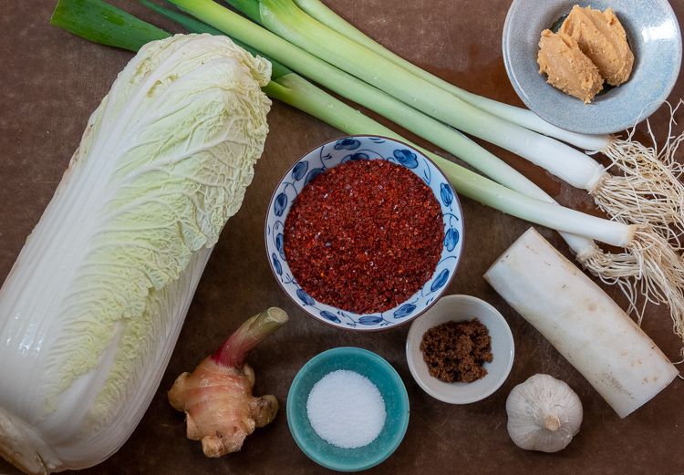 Vegan kimchi ingredients: Napa cabbage, ginger root, scallions, daikon, garlic, salt, sugar, gochugaru.